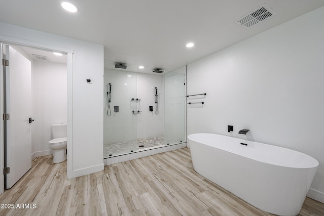 7201 N 16th Dr, Phoenix, AZ 85021 - bathroom with a shower stall, a freestanding tub, wood finished floors, toilet, and recessed lighting
