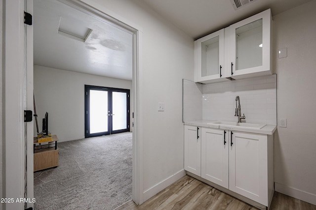 7201 N 16th Dr, Phoenix, AZ 85021 - bar area featuring a sink, decorative backsplash, baseboards, and french doors
