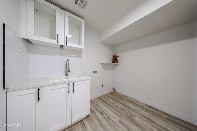 7201 N 16th Dr, Phoenix, AZ 85021 - laundry area featuring washer hookup, cabinet space, light wood-type flooring, and baseboards