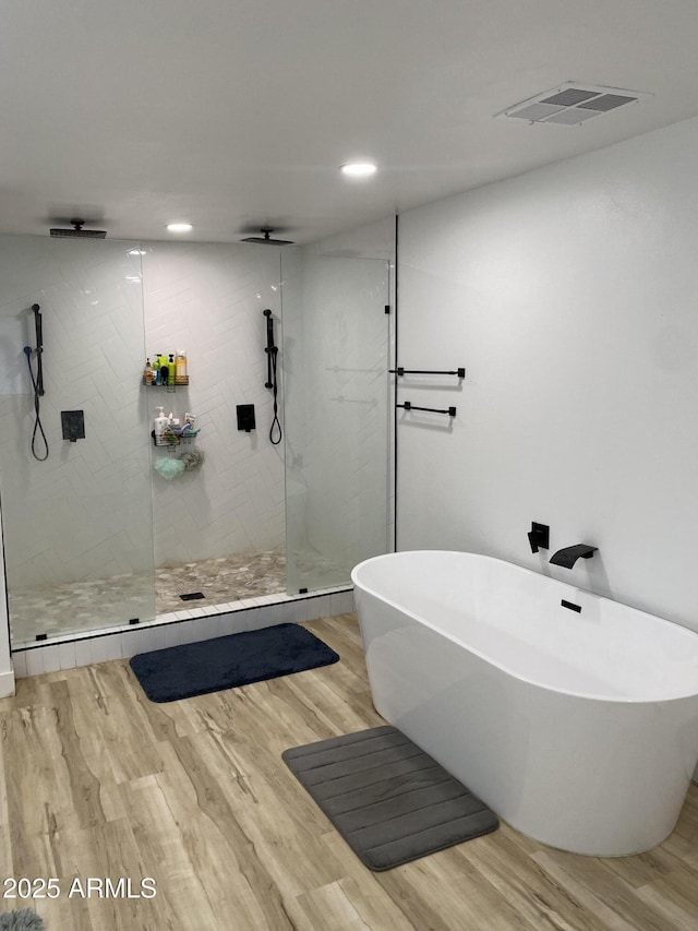 7201 N 16th Dr, Phoenix, AZ 85021 - bathroom featuring walk in shower, a freestanding tub, wood finished floors, and recessed lighting