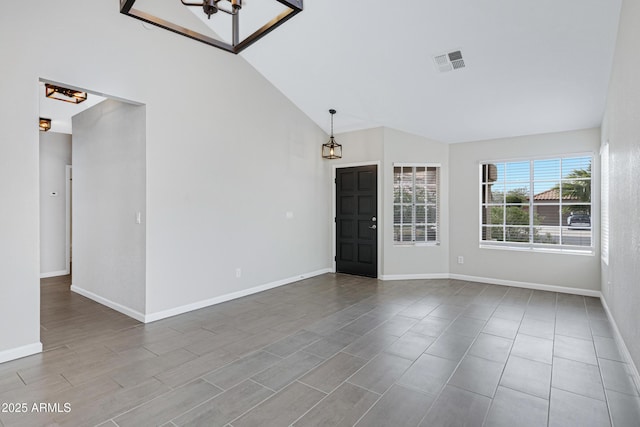 spare room with high vaulted ceiling, visible vents, and baseboards