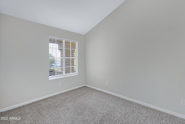 empty room featuring baseboards, carpet, and lofted ceiling