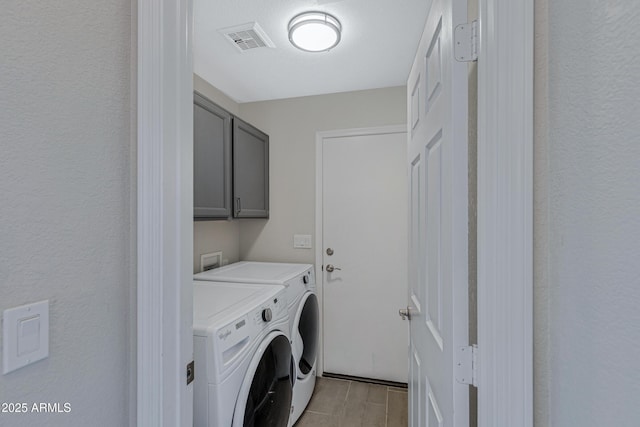 laundry room featuring visible vents, independent washer and dryer, and cabinet space