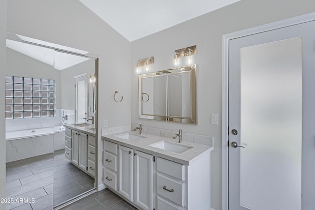 full bath with a garden tub, double vanity, a sink, and lofted ceiling