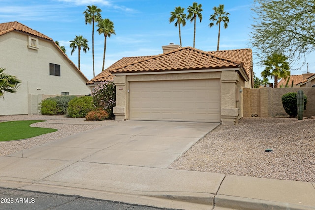 mediterranean / spanish home featuring a garage, a chimney, concrete driveway, a tile roof, and stucco siding
