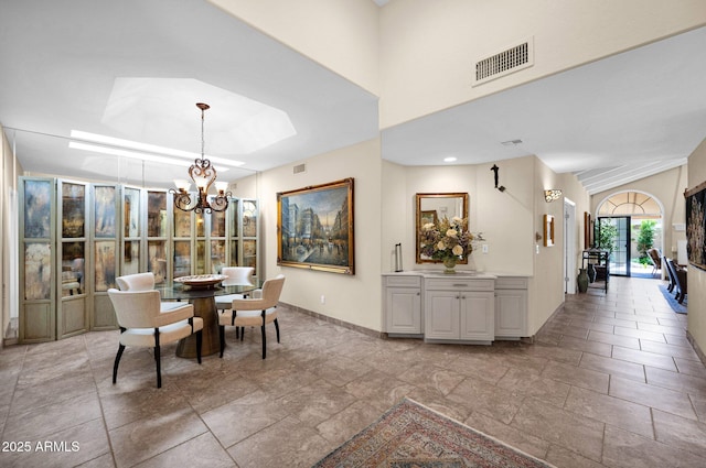 dining room featuring baseboards, a notable chandelier, and visible vents