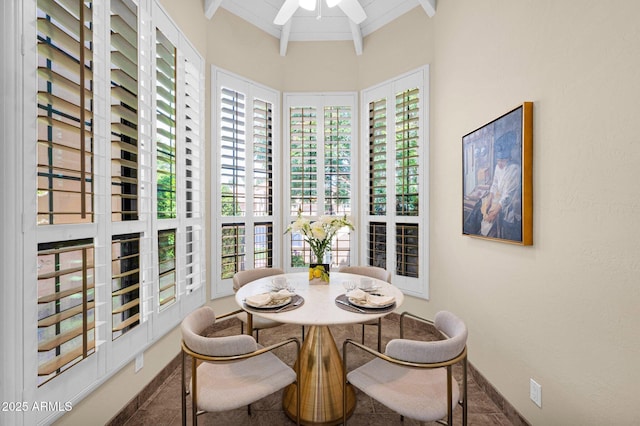 tiled dining space featuring baseboards, ceiling fan, and beam ceiling