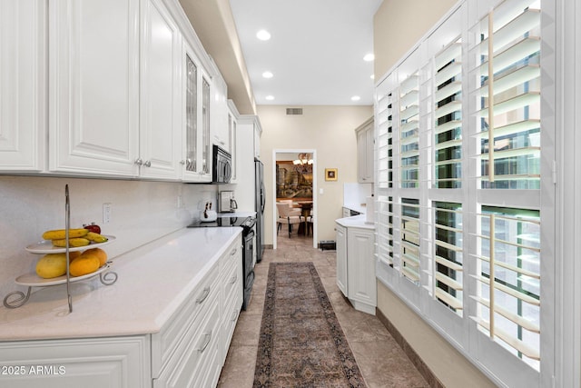 kitchen with white cabinets, electric range, recessed lighting, stainless steel microwave, and visible vents