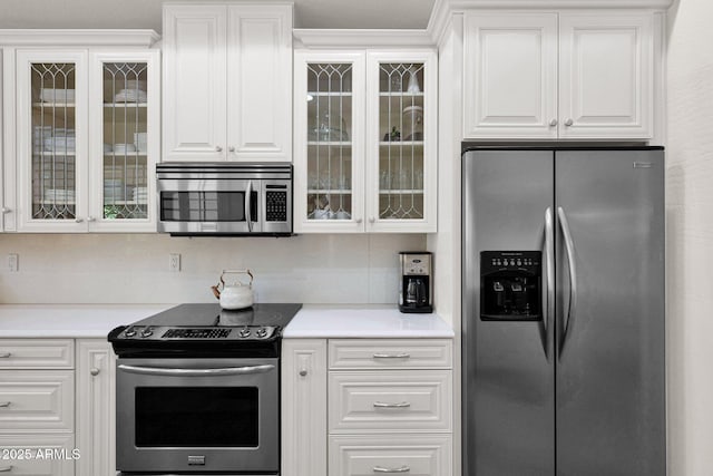 kitchen with white cabinets, stainless steel appliances, glass insert cabinets, and light countertops