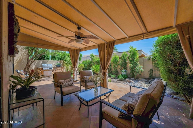 view of patio / terrace featuring a fenced backyard, a ceiling fan, an outdoor hangout area, and an outdoor kitchen