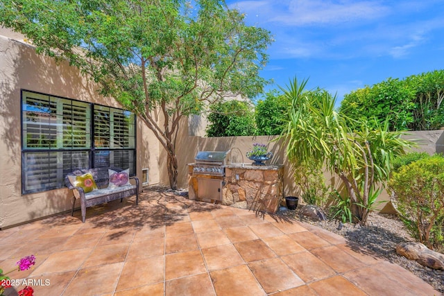 view of patio with area for grilling and fence