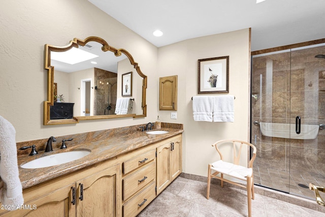 full bathroom with a sink, baseboards, a stall shower, and double vanity