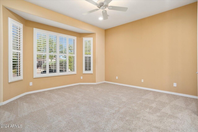 spare room featuring light colored carpet and ceiling fan