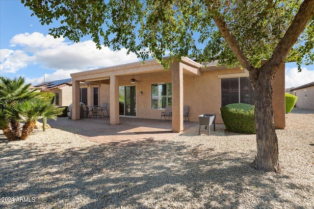 back of property featuring ceiling fan and a patio