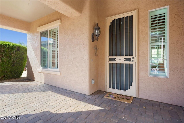 view of exterior entry with a patio