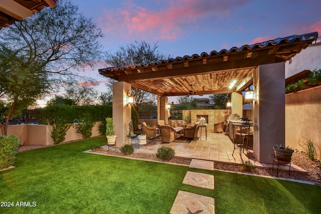 patio terrace at dusk featuring a yard