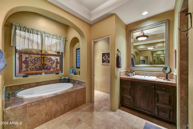 bathroom with tiled bath and vanity