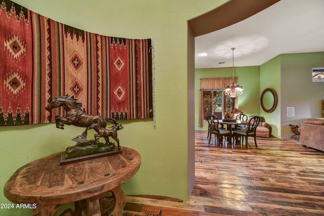 hall featuring a notable chandelier and hardwood / wood-style flooring