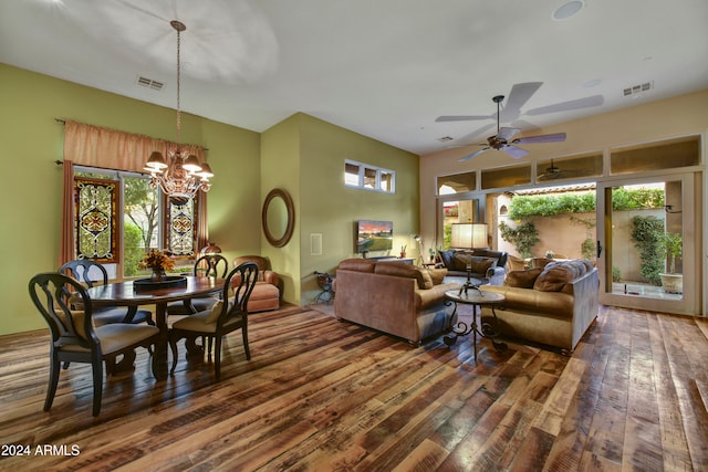 living room with ceiling fan with notable chandelier, plenty of natural light, and dark wood-type flooring