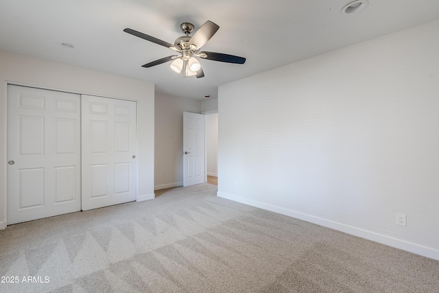 unfurnished bedroom featuring ceiling fan, a closet, and light carpet