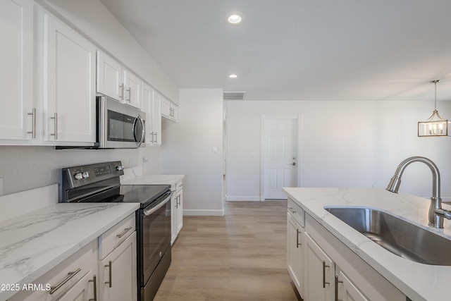 kitchen with sink, pendant lighting, white cabinetry, light hardwood / wood-style flooring, and range with electric cooktop