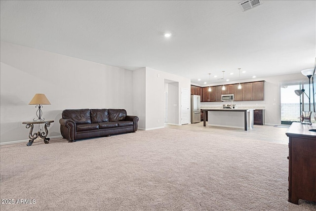 living room featuring light carpet, visible vents, recessed lighting, and baseboards