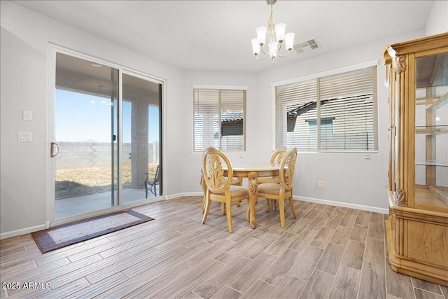 dining space featuring a chandelier, visible vents, baseboards, and wood finish floors
