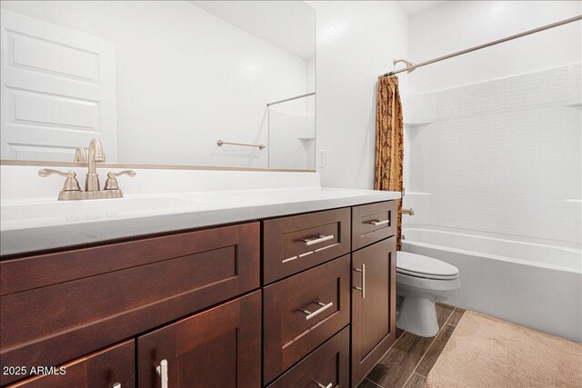 bathroom with shower / bath combo with shower curtain, toilet, wood finished floors, and vanity