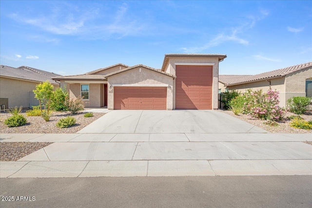 view of front of home featuring a tiled roof, stucco siding, driveway, and a garage