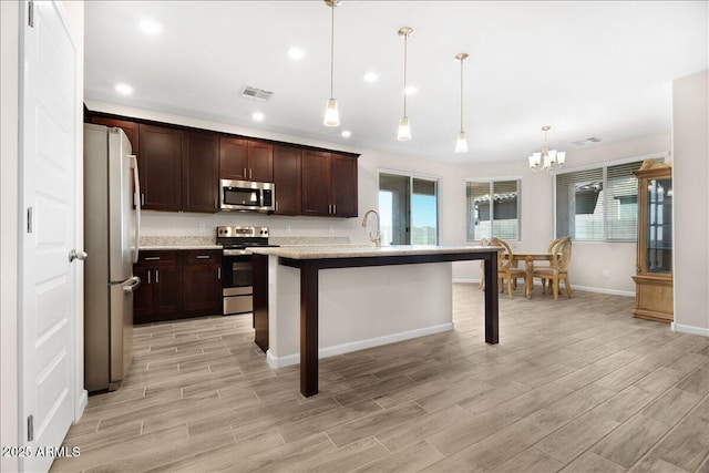 kitchen featuring a wealth of natural light, stainless steel appliances, visible vents, and wood tiled floor