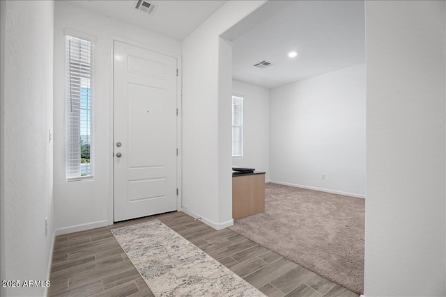 foyer featuring visible vents, plenty of natural light, and wood tiled floor