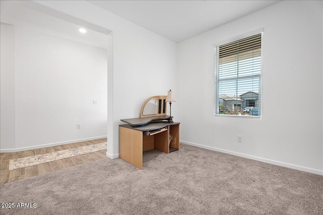 office area with baseboards and light carpet