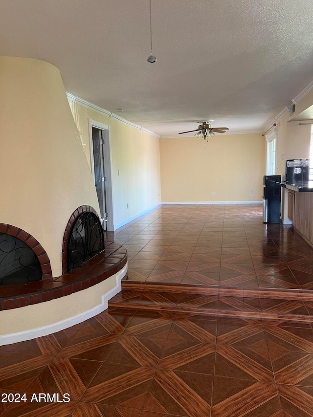 unfurnished living room featuring ornamental molding, ceiling fan, and a textured ceiling