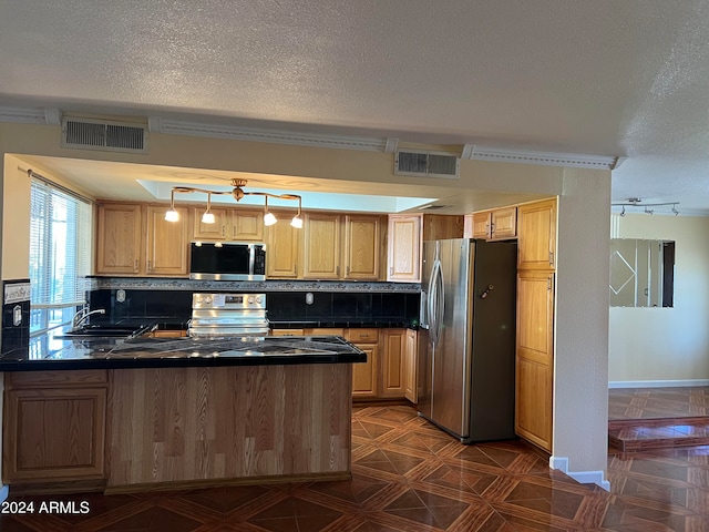 kitchen featuring a textured ceiling, stainless steel appliances, and tasteful backsplash