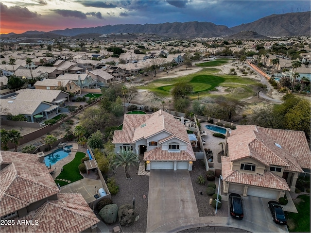 aerial view at dusk featuring a mountain view and a residential view