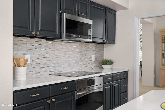 kitchen with decorative backsplash, stainless steel appliances, and dark cabinets