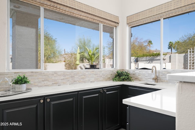 kitchen with decorative backsplash, plenty of natural light, and dark cabinets