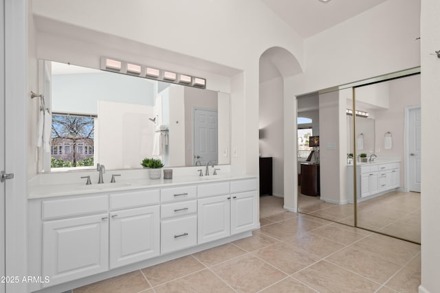 bathroom with double vanity, a healthy amount of sunlight, tile patterned floors, and a sink