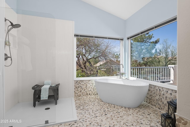 full bathroom with a soaking tub, walk in shower, and vaulted ceiling