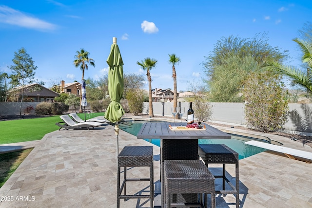 view of swimming pool featuring a patio, a fenced in pool, a fenced backyard, a diving board, and a lawn