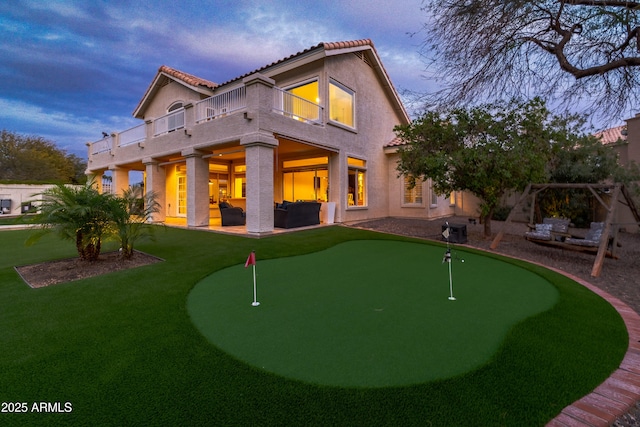 back of property with stucco siding, an outdoor hangout area, a yard, a balcony, and a patio area