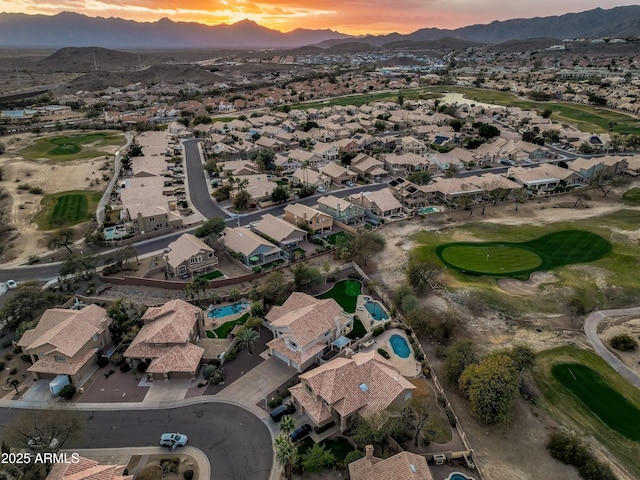 aerial view at dusk with a mountain view, a residential view, and view of golf course