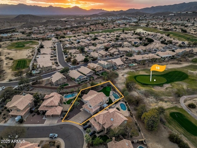 aerial view at dusk with a mountain view, a residential view, and view of golf course