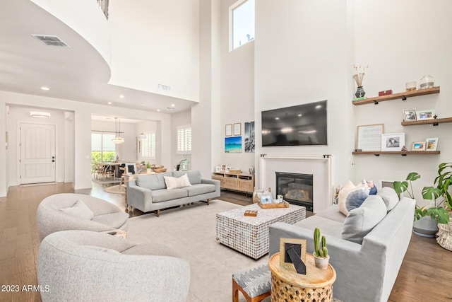 living room with a high ceiling and hardwood / wood-style floors