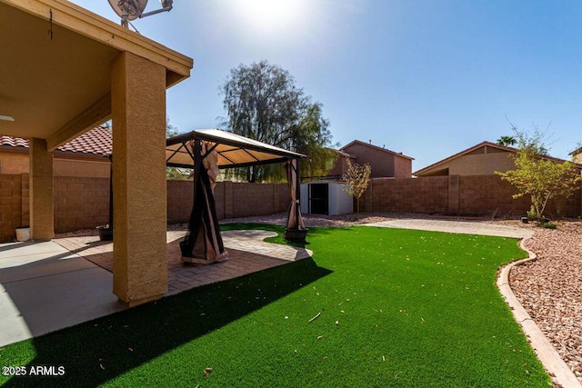 view of yard with an outbuilding, a patio, a shed, and a fenced backyard