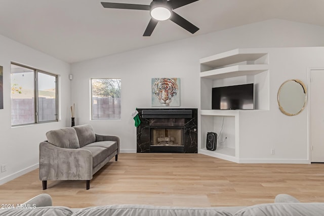 living room featuring light wood-type flooring, ceiling fan, and vaulted ceiling