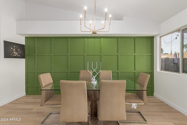 dining area with vaulted ceiling, a chandelier, and light wood-type flooring