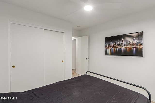 unfurnished bedroom with ceiling fan and a closet