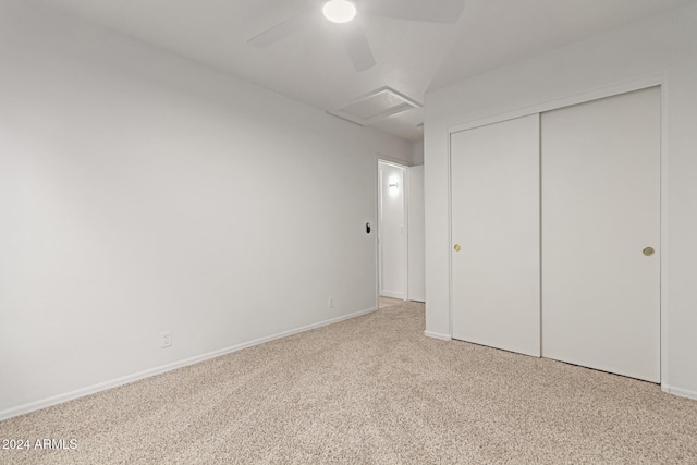 unfurnished bedroom featuring ceiling fan, light colored carpet, and a closet