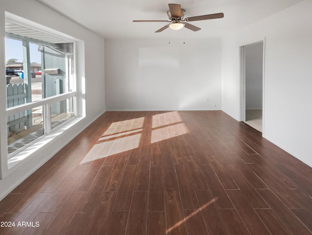 empty room with ceiling fan and dark wood-type flooring